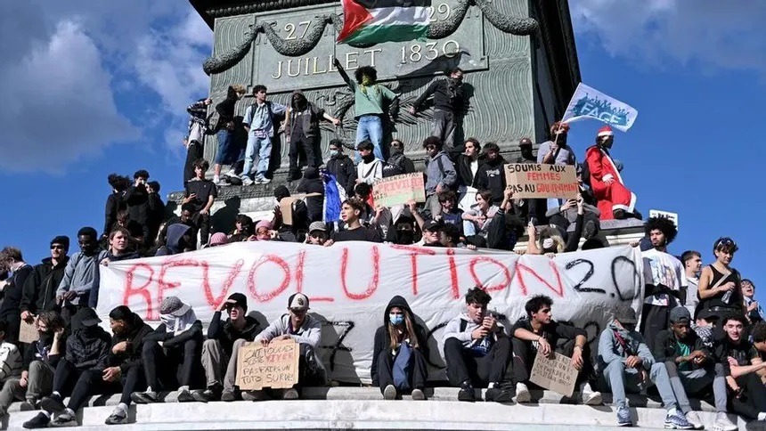 Manifestantes en París con pancarta de protesta